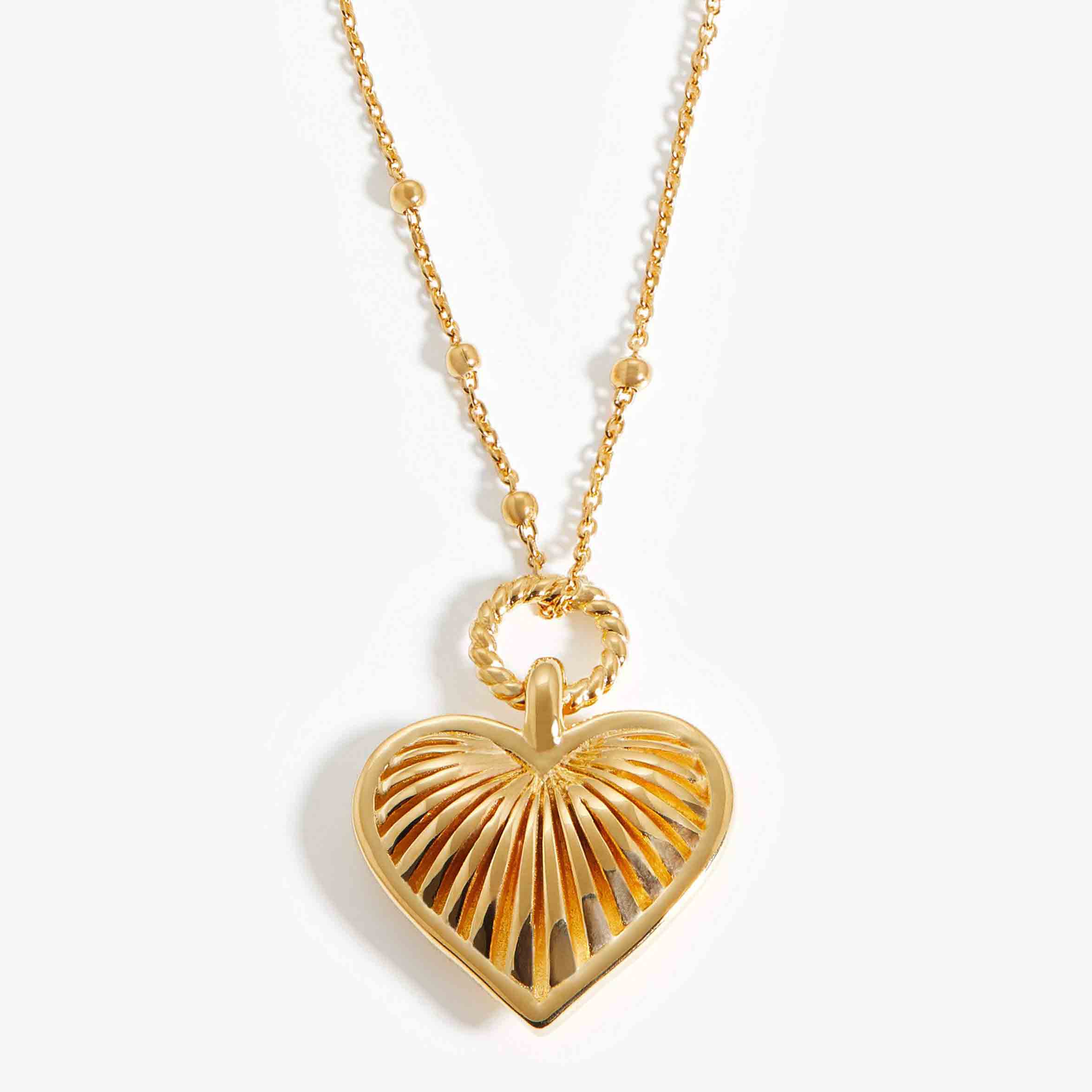 El fabricante de joyas de oro vermeil hace un collar con dije de corazón en plata chapada en oro de 18k
